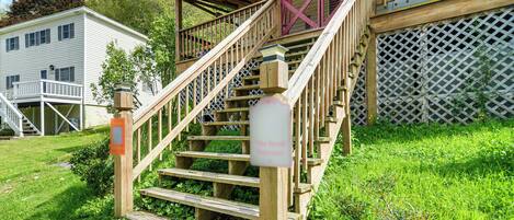 A wooden staircase leading to a covered porch with a metal railing.
