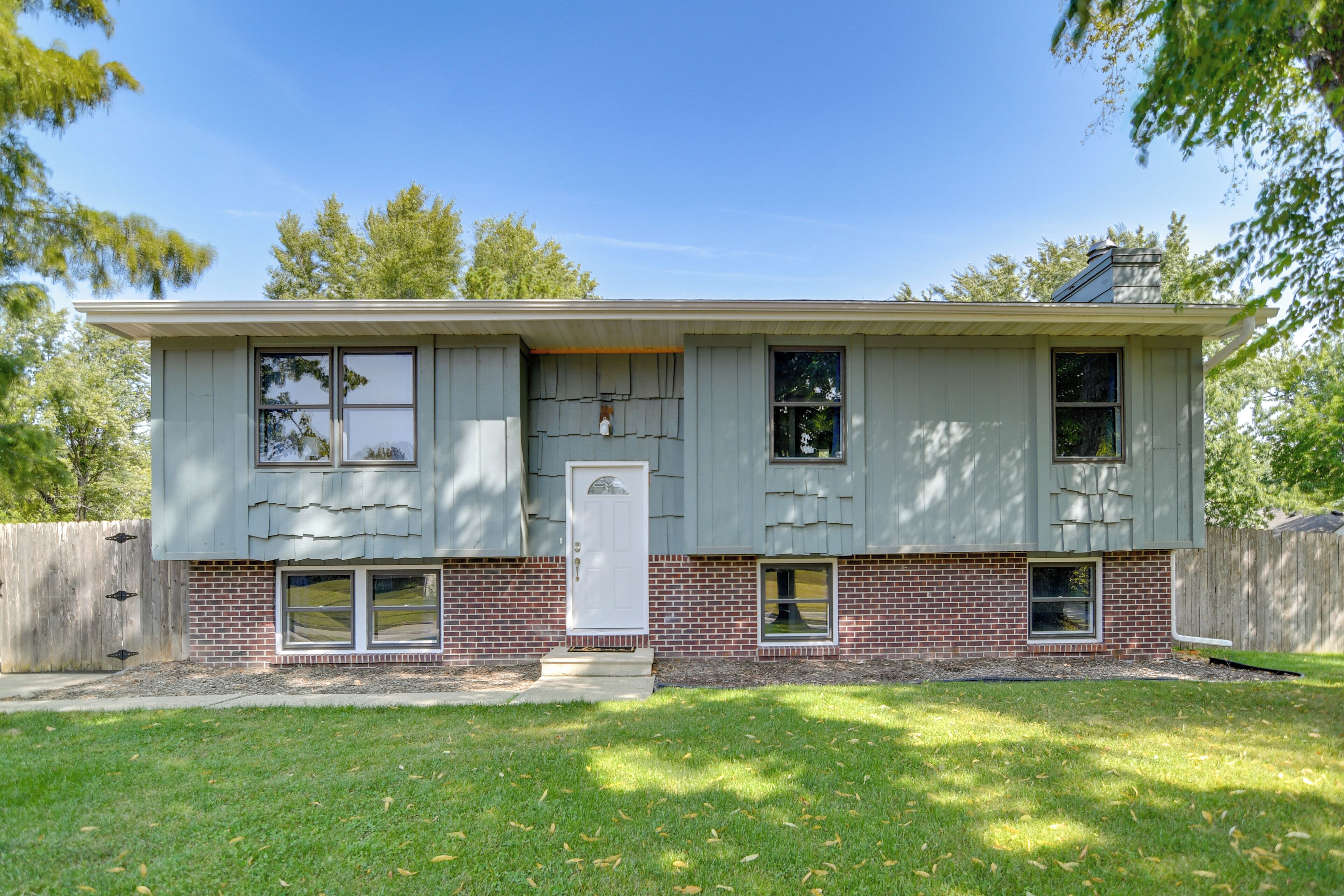 A two-story house with a brick foundation and a flat roof.