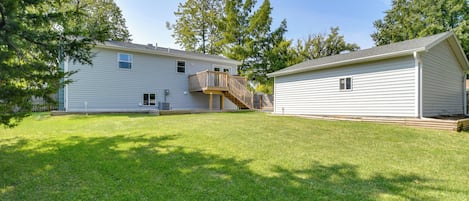 A two-story house with a wooden deck and a separate garage.