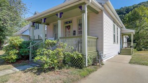 A two-story house with a porch, a front yard, and a staircase leading to the front door.