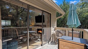 A covered outdoor patio with glass doors, a fire pit, and outdoor furniture. - 2D West Hyde Park - Your New Favorite Beach Villa (Myrtle Beach)