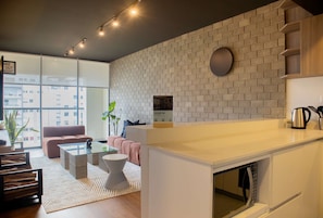 Una sala moderna con un sofá, una mesa de centro y una mesita auxiliar.