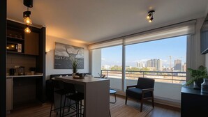 Eine moderne Küche mit Bar, großen Fenstern und Blick auf die Stadt.