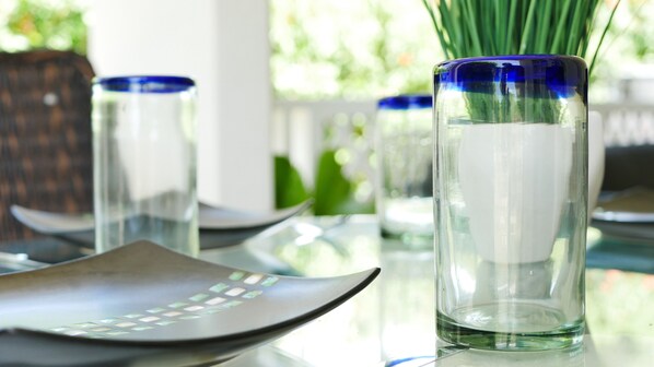 A dining table with clear glassware and a modern, geometric-patterned placemat.