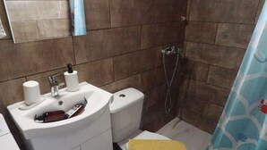 A bathroom with a sink, toilet, and shower.