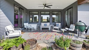 A covered patio with seating, a grill, and potted plants. - Peaceful Secluded Wausau Retreat 3 Bedroom Home (Wausau)