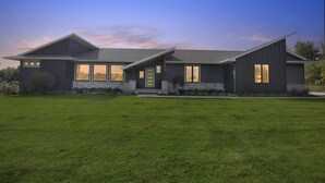 A modern two-story house with a well-maintained lawn, large windows, and a prominent front porch. - Peaceful Secluded Wausau Retreat 3 Bedroom Home (Wausau)