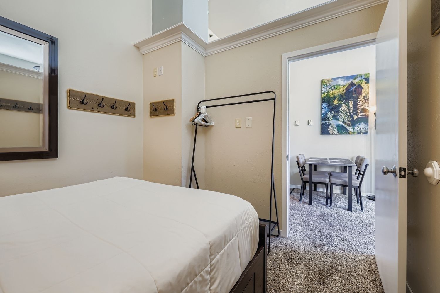 Un dormitorio con cama, escritorio y silla en un pasillo.
