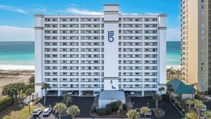 Un hôtel à plusieurs étages, reconnaissable à son grand logo « 5 », doté d’un parking et offrant une vue sur la plage.