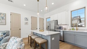 A modern kitchen with white cabinets, a stainless steel refrigerator, and a large window. - - Chic New Home - Walk to River Ranch - King Bed - 2 Master Suites- A+ Location. (Lafayette)