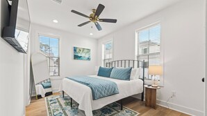 A bedroom with a bed, a ceiling fan, a bedside table with a lamp, and a window with blinds. - - Chic New Home - Walk to River Ranch - King Bed - 2 Master Suites- A+ Location. (Lafayette)