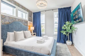 Ein modernes Hotelzimmer mit einem großen Bett, einem Flachbildfernseher und einer Zimmerpflanze.
