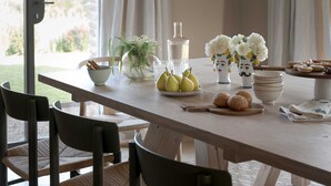 A dining table with a bowl of pears, a pitcher, and a vase with flowers. - Il Mandorlo by Boutique (San Quirico d'Orcia)