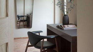 A modern, minimalist room with a large mirror, a desk, and a chair. - Il Mandorlo by Boutique (San Quirico d'Orcia)