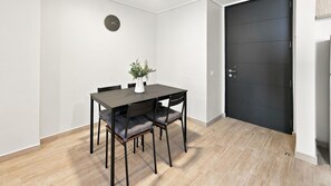 Un comedor con una mesa, sillas, un reloj en la pared y una puerta.