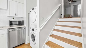A kitchen with white cabinets, a microwave, and a dishwasher.