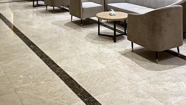 Eine moderne Hotelhalle mit einer langen Rezeption, mehreren Sesseln und einer Sitzecke.