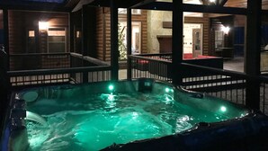 Ein Whirlpoolbereich mit Blick auf eine Holzhütte und einen Weihnachtsbaum.