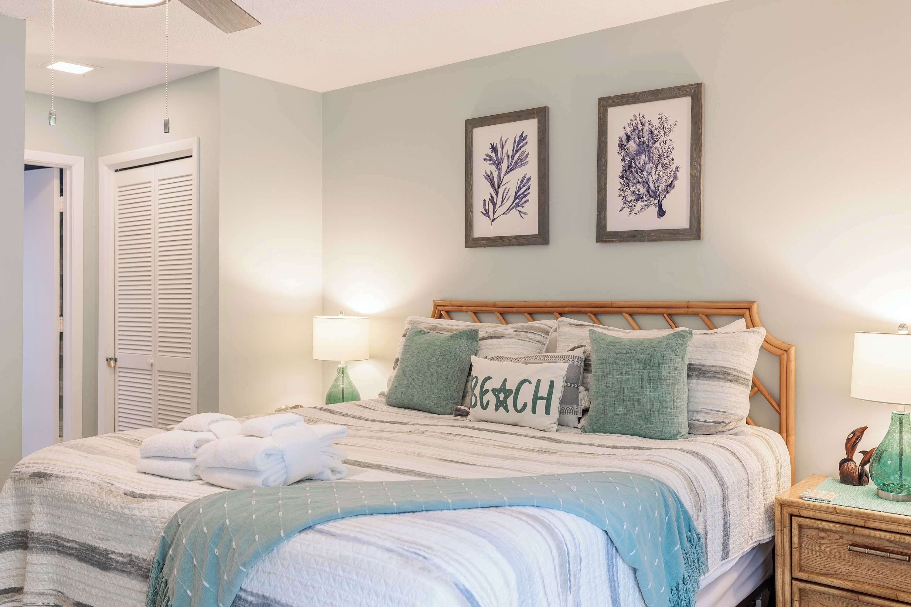 A bedroom with a bed, two wall-mounted lamps, a nightstand, and a door.