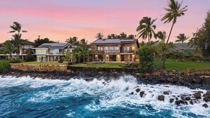 A coastal property with a large house featuring multiple levels, a balcony, and a view of the ocean. - Kukuiula Bay House By Parrish - Oceanfront Family Home (Koloa)
