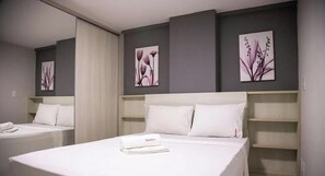 A hotel room with two beds, white bedding, and artwork on the walls. - Antonino Cavalcanti - LikeHome Accommodations (João Pessoa)
