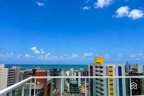 Un edificio de gran altura con varios balcones que dan a una ciudad costera.