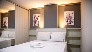 Et hotelværelse med en stor seng, to sengeborde og billedkunst på væggene.