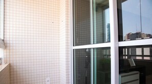 A modern hotel room with a large window, tiled walls, and a small desk with a chair. - Antonino Cavalcanti - LikeHome Accommodations (João Pessoa)