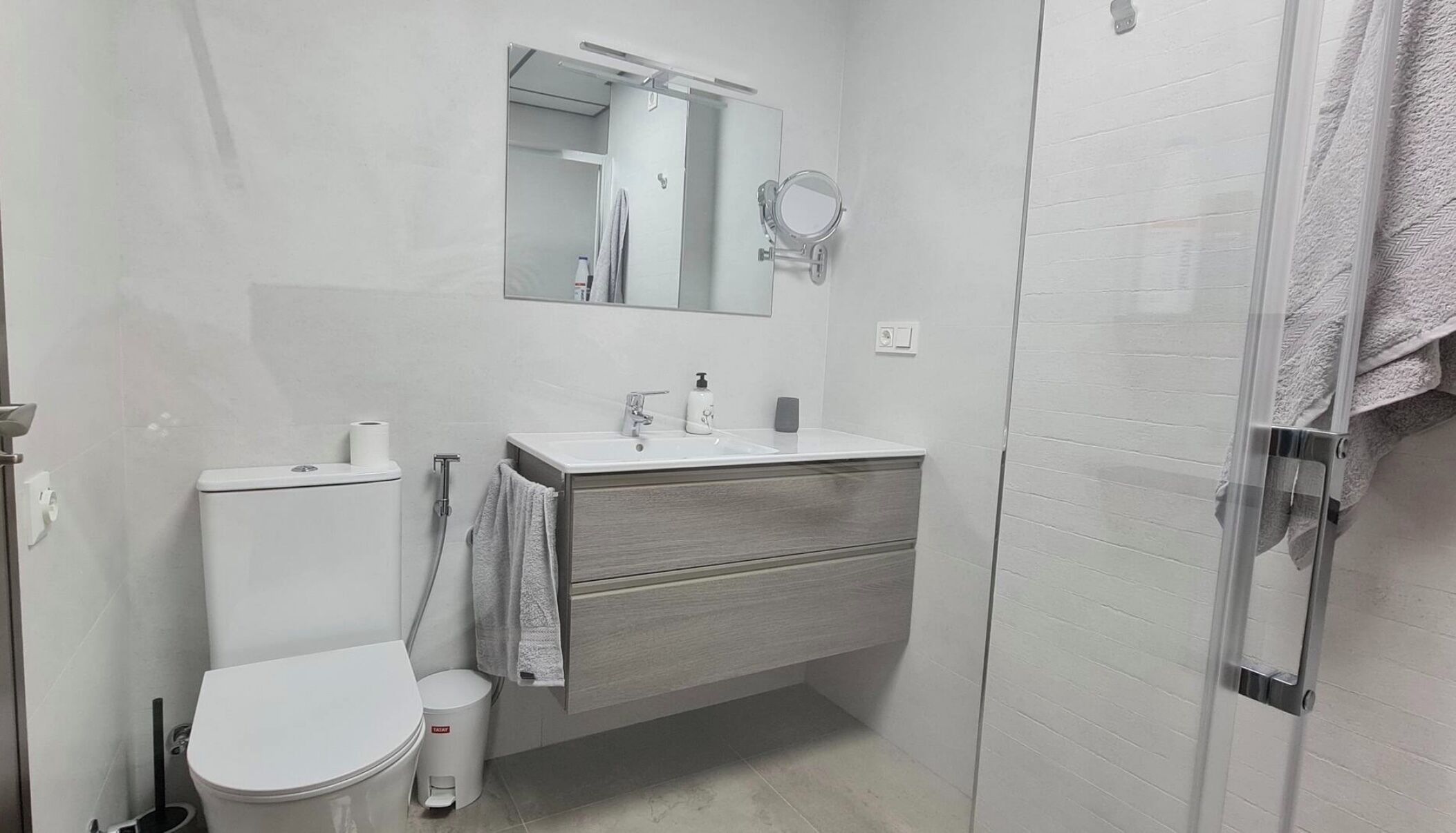 Een haardroger, handdoeken, zeep, toiletpapier