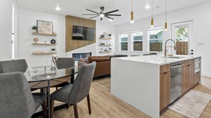 Una cocina moderna con una isla central, armarios de madera y un televisor integrado.