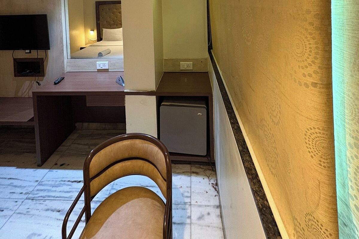 Ein Hotelzimmer mit einem Bett, einem Schreibtisch, einem Fernseher und einem kleinen Kühlschrank.