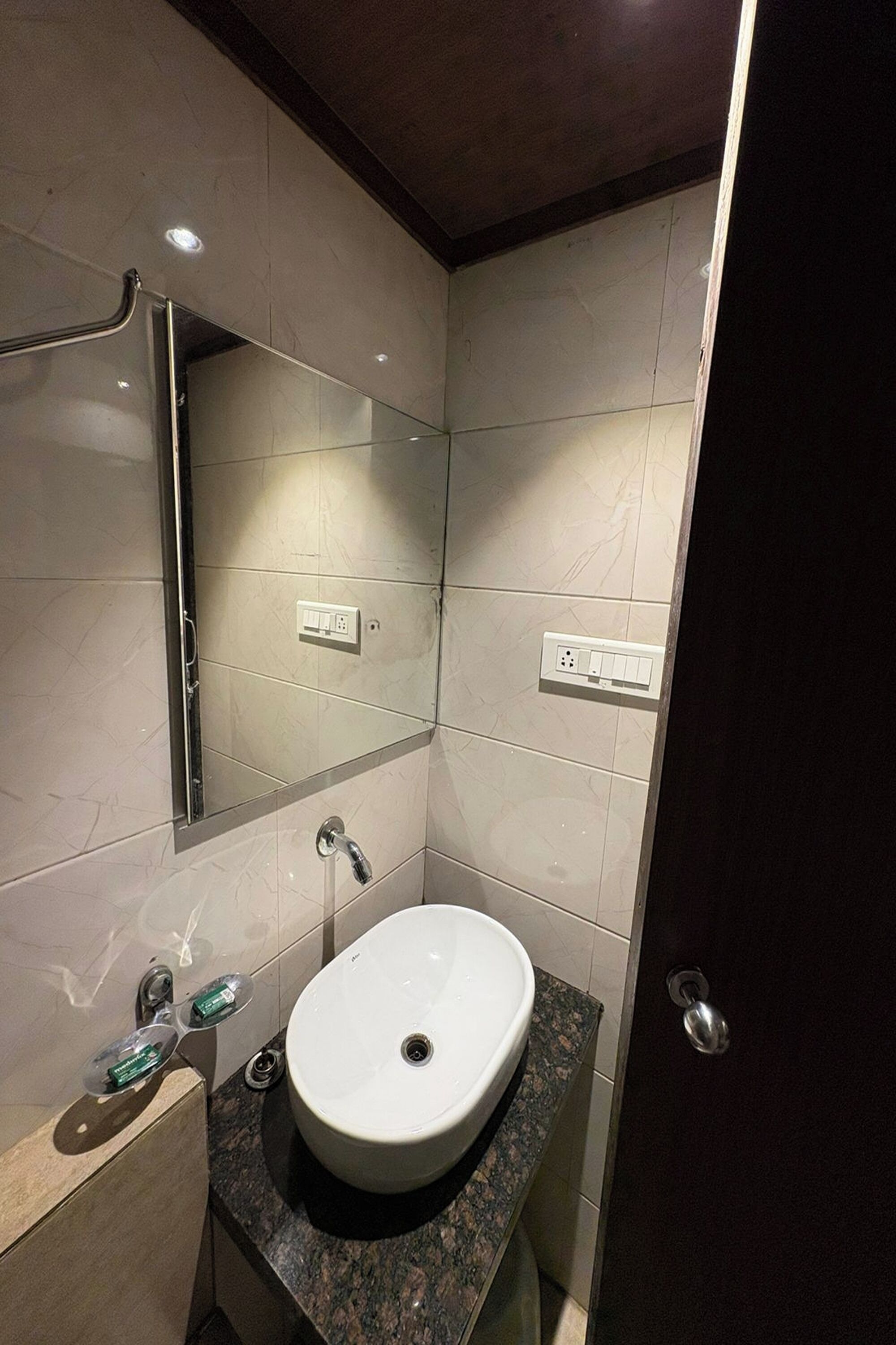 A bathroom with a white sink, a mirror, and a towel rack.