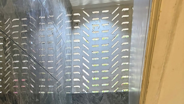 A staircase with marble walls and a metal railing. - Pravasi Residency (Mumbai)