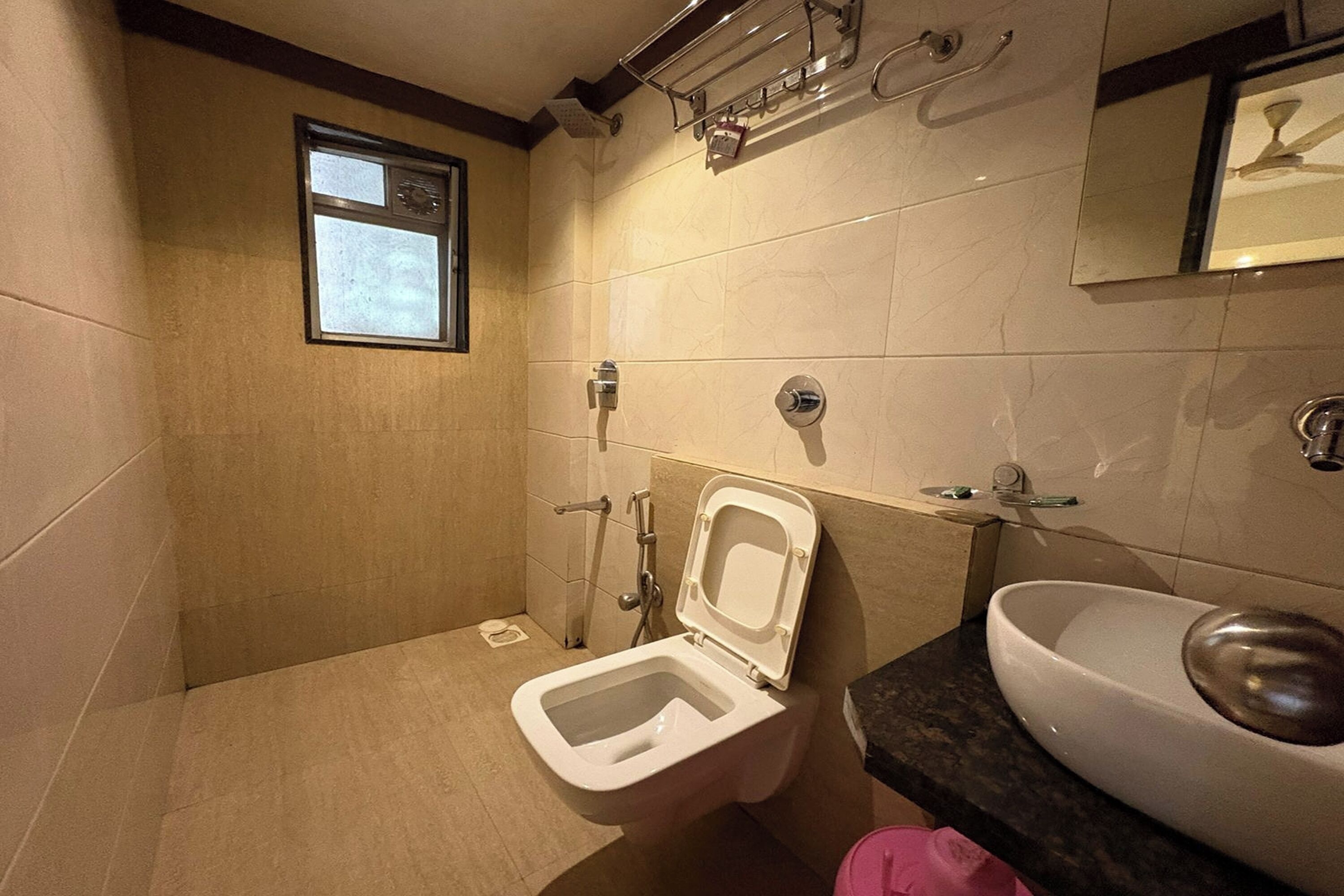 A bathroom with a toilet, sink, and shower.