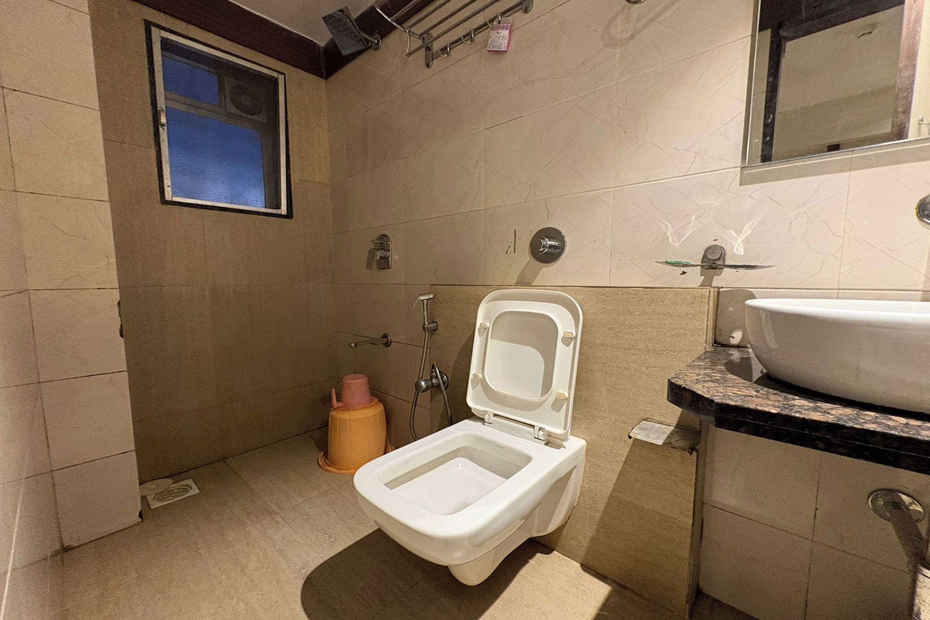 Un baño pequeño con inodoro, lavamanos y ducha.