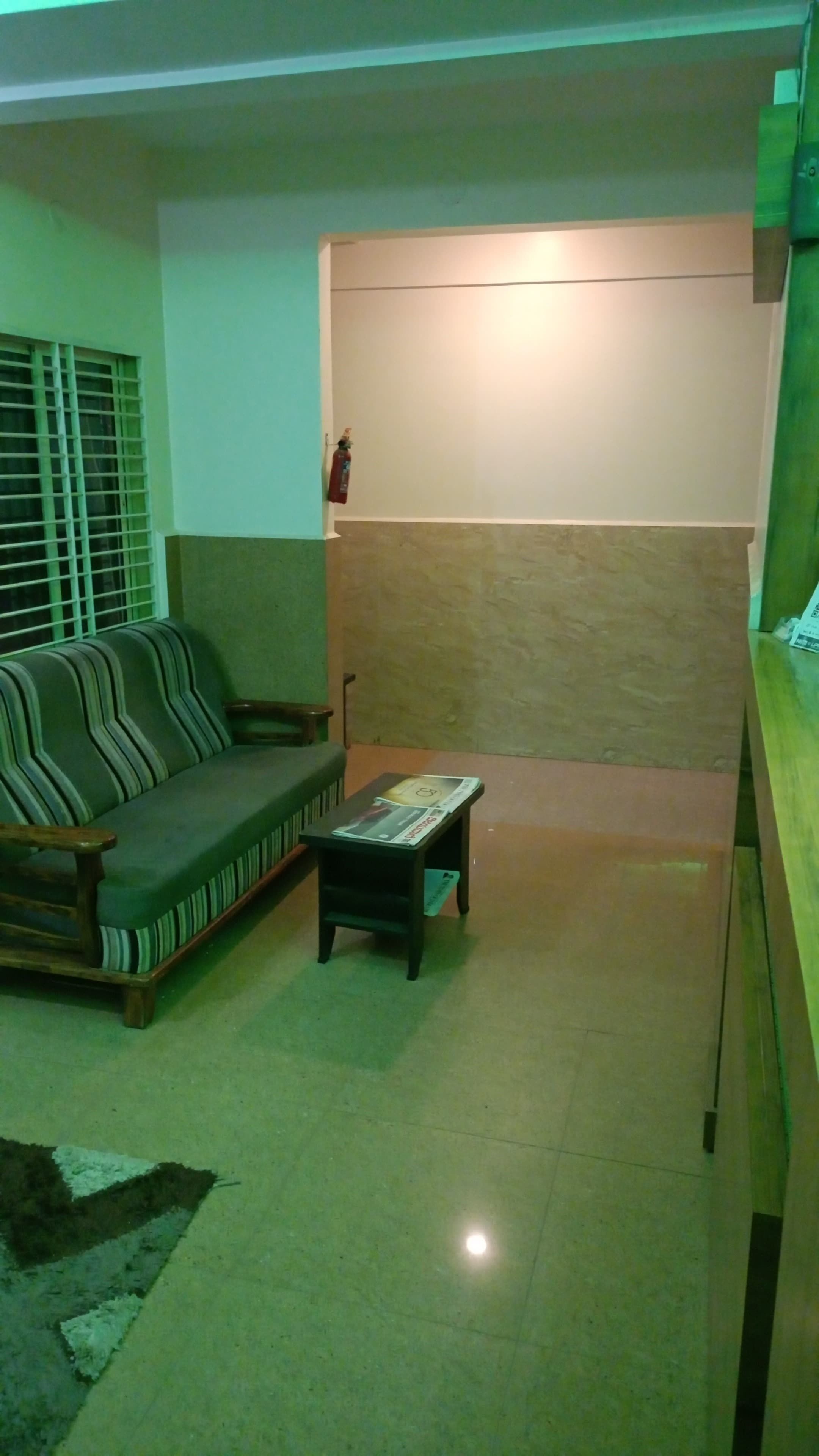 Una sala de estar con un sofá, una mesa de centro y un ventanal con persianas.