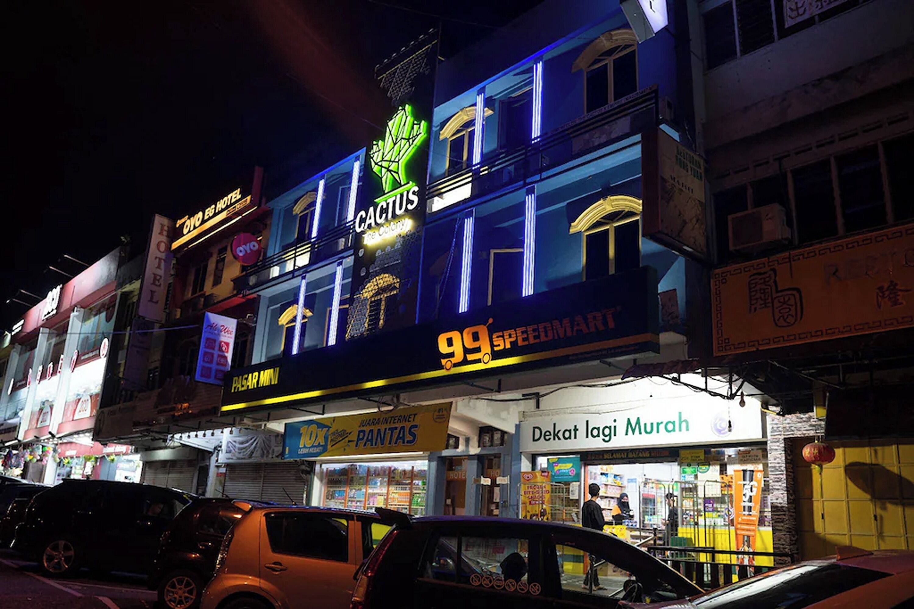 A building with multiple signs including 'Cactus', '99 SpeedMart', and 'Dekat Laji Murah'.