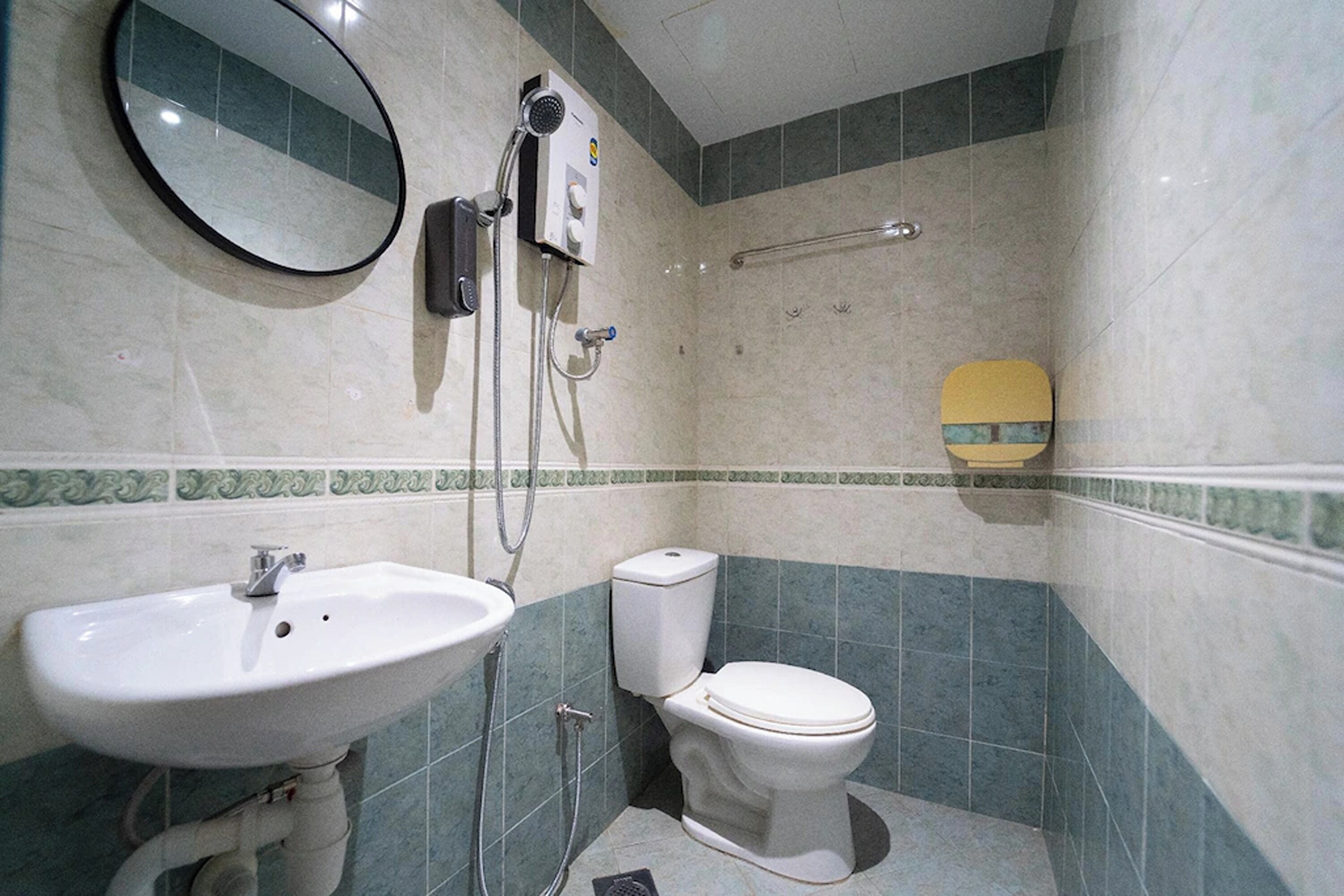 Een badkamer met een wastafel, toilet en spiegel.