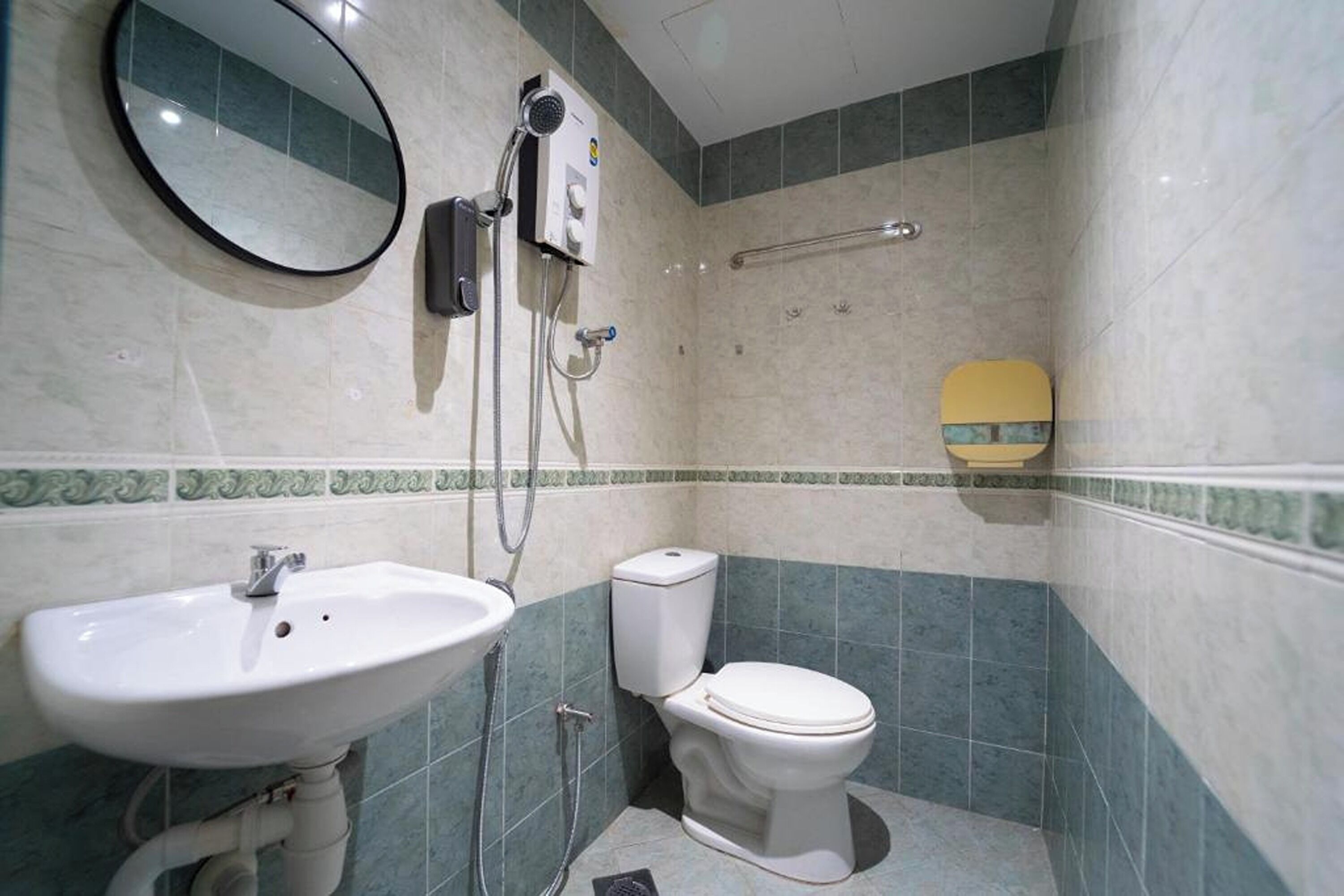 Un baño con lavamanos, inodoro y ducha.