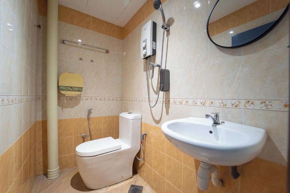Une salle de bain comprenant des toilettes, un lavabo, une douche et un miroir.