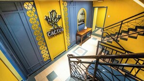 A staircase with a handrail, a wall with a geometric pattern, and a sign that reads "CACTUS". - The Colony By Cactus Hotel Johor Jaya (Johor Bahru)