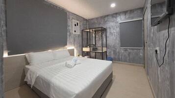 Un dormitorio moderno con una cama grande, una mesita de noche con lámpara y un armario con espejo.