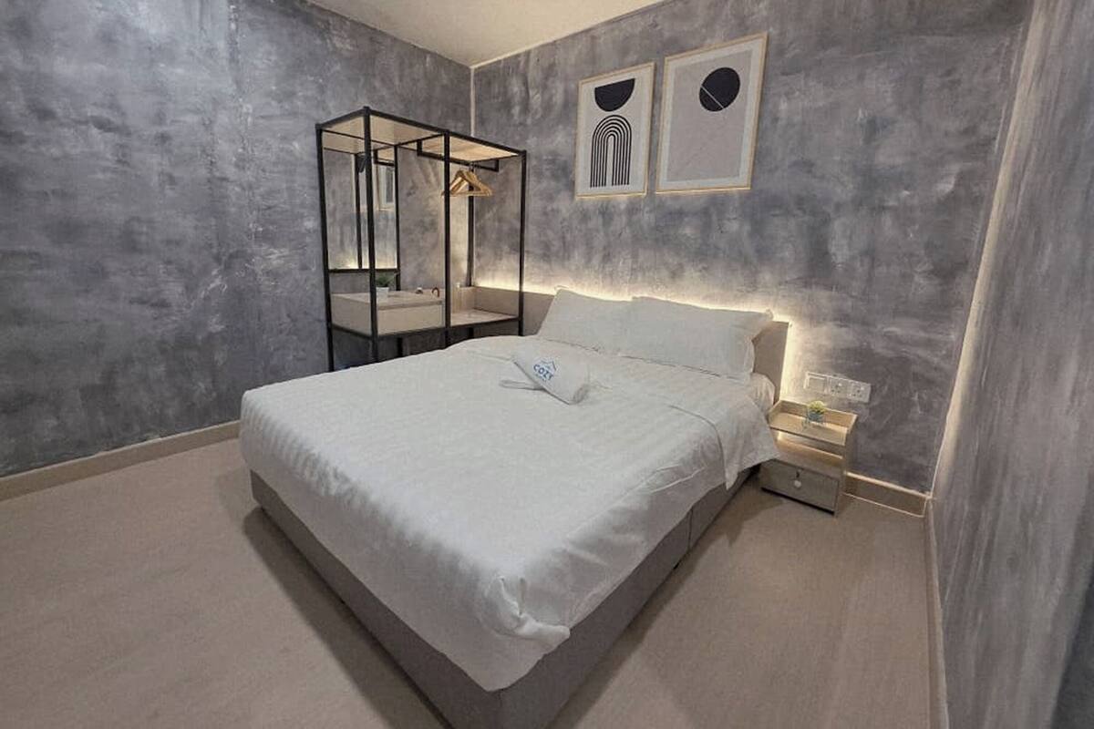 Una camera da letto moderna con un letto grande, un comodino, uno specchio e due opere d'arte appese alla parete.