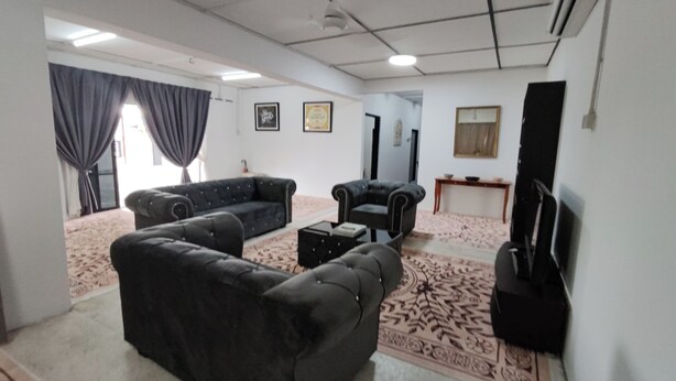 A living room with a sofa set, a coffee table, a TV, and a patterned rug. - Drh Villa (Ipoh)