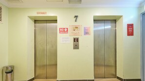 Een lift met een 'Niet roken'-bordje, een '7' erboven en een bord met 'Uitchecktijd'.