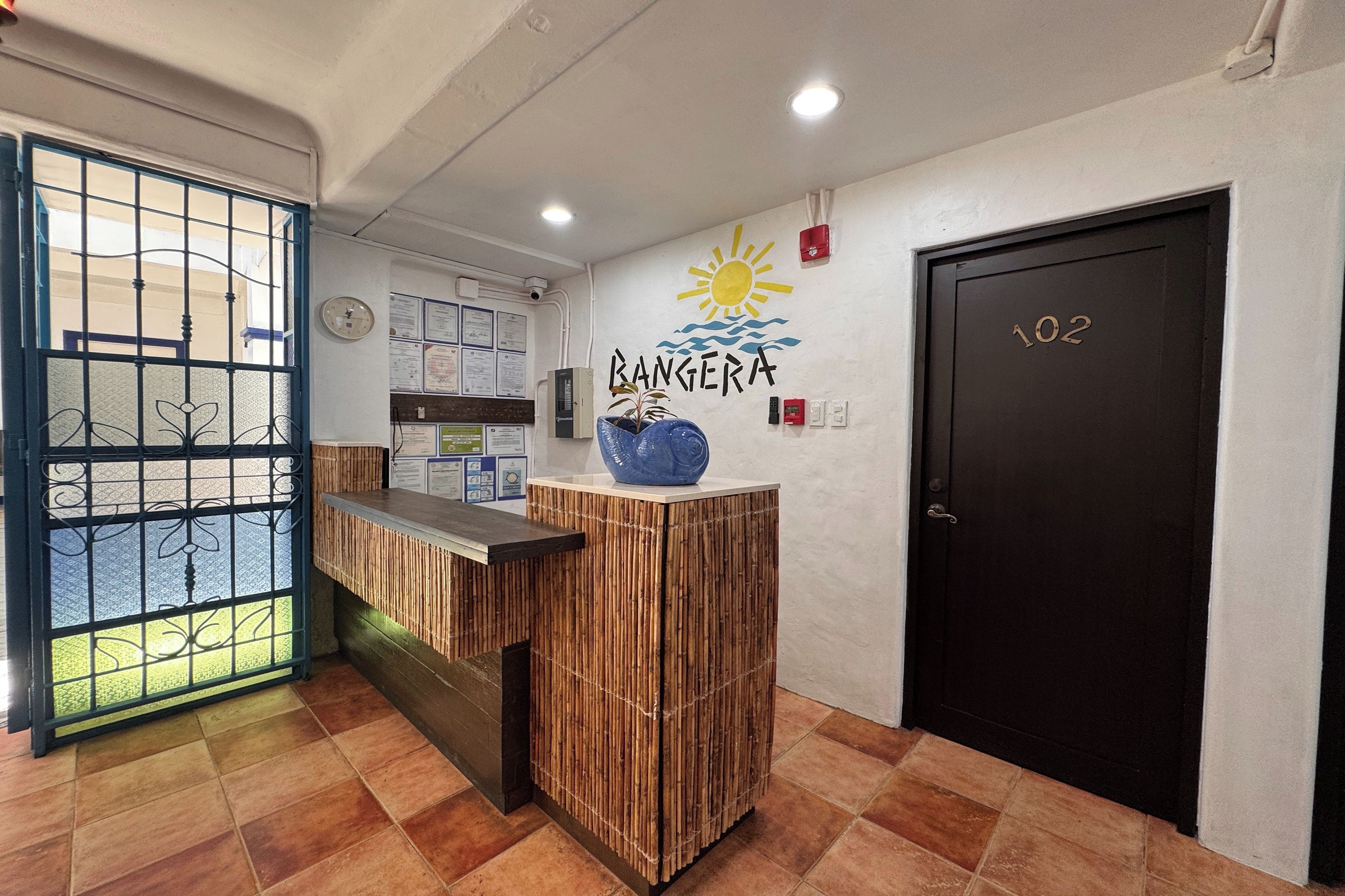 Una recepción con un reloj, certificados y una pared con un diseño de sol y agua.