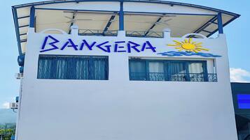 Un edificio con un letrero que dice 'BANGERA' y un símbolo de sol, indicando un hotel o resort.