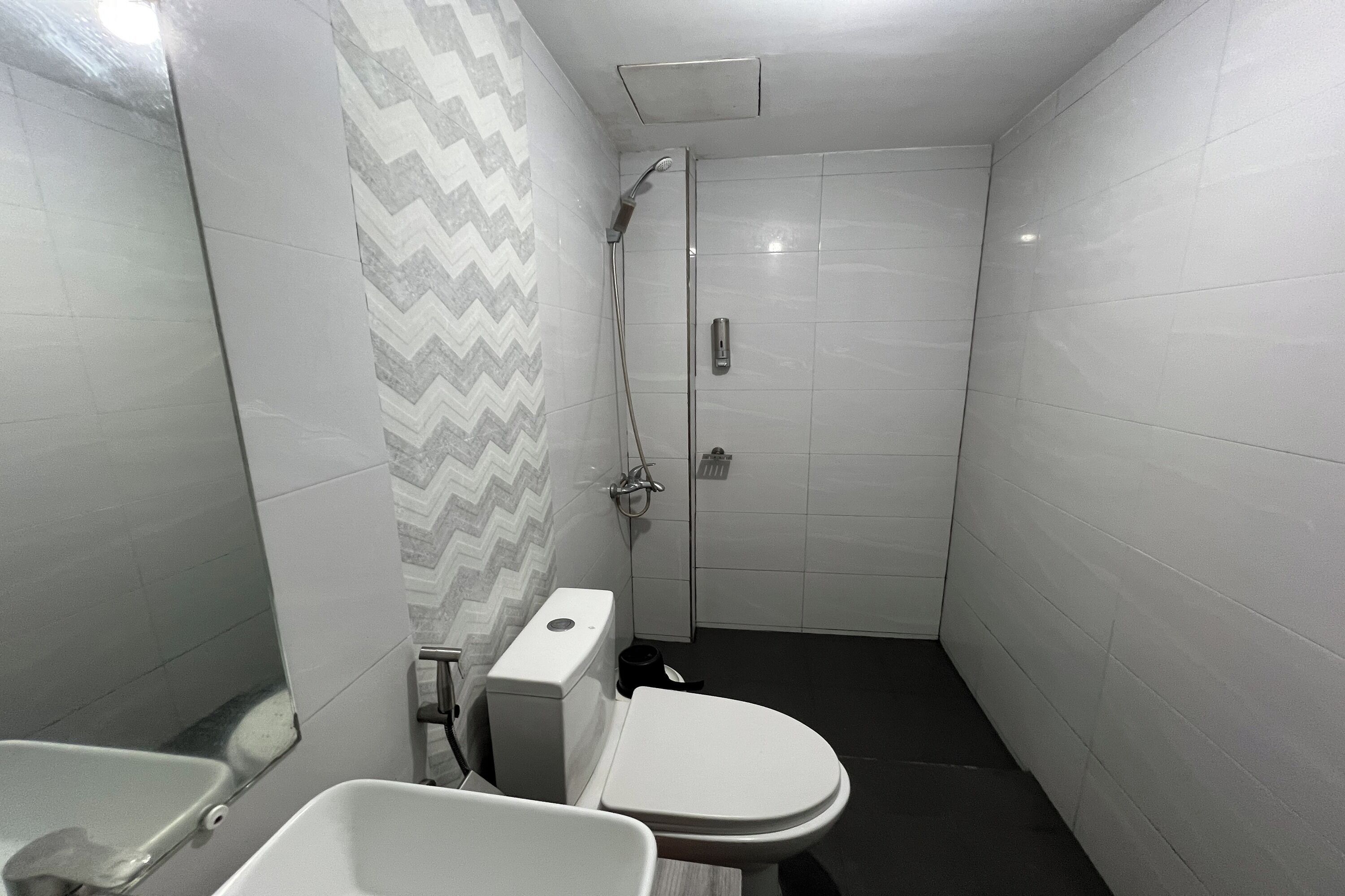 A small, modern bathroom with a toilet, bidet, and shower.