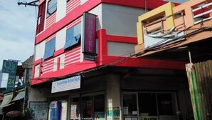 Un edificio a più piani con insegna per ostello, vetrina ben visibile e vista sulla strada.
