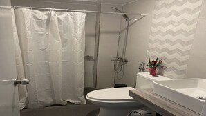 Un bagno moderno con doccia, toilette e lavandino.